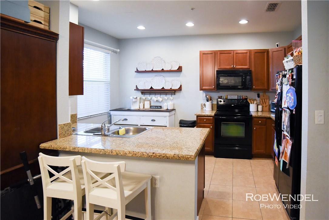 2851 Prospect Road, Unit 405 Tamarac, FL 33309 - Photo 5 of 25 a kitchen with kitchen island granite countertop a sink a counter top space and stainless steel appliances
