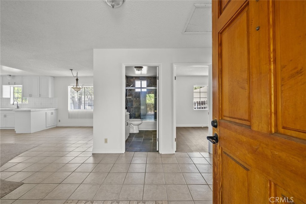 a view of a hallway with bathroom and a shower
