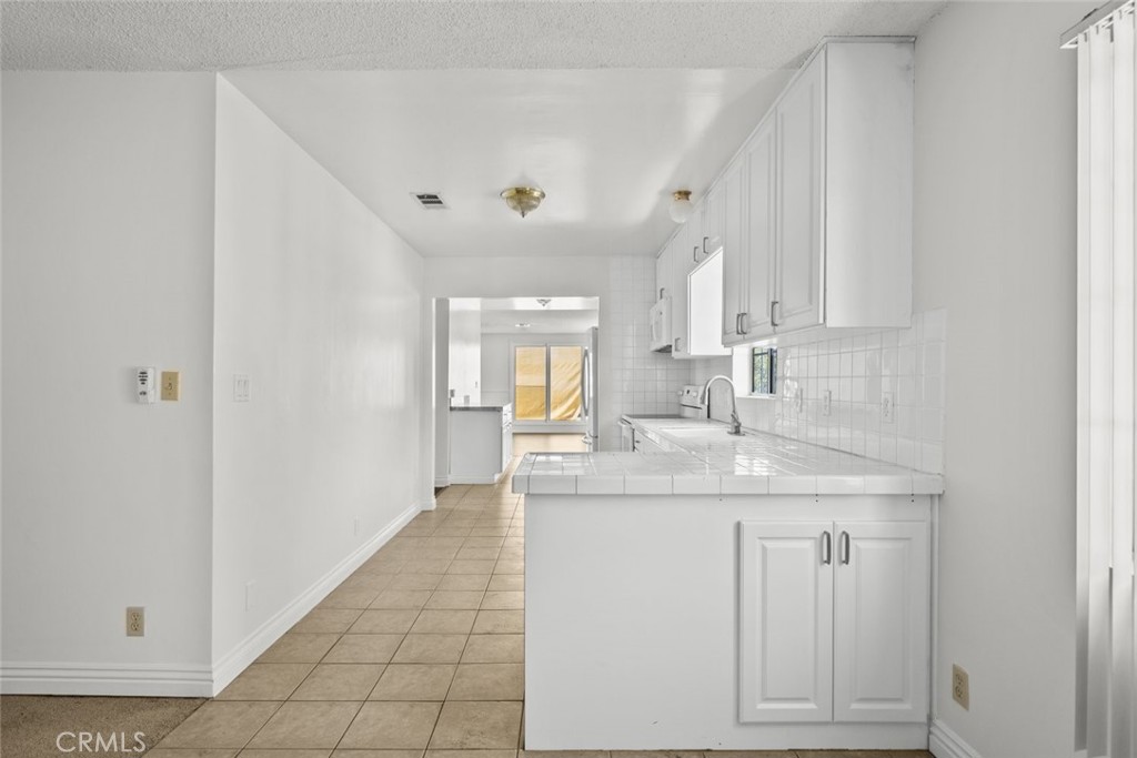 10528 1/2 Hillhaven Avenue Tujunga, CA 91042 - Photo 15 of 28 a kitchen with stainless steel appliances granite countertop a sink and dishwasher with white cabinets