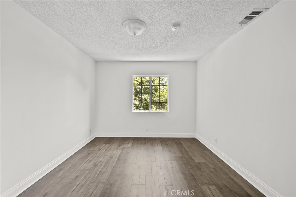 10528 1/2 Hillhaven Avenue Tujunga, CA 91042 - Photo 21 of 28 an empty room with wooden floor and windows