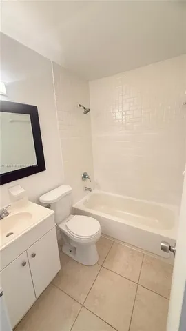 a bathroom with a toilet a sink a mirror and bathtub