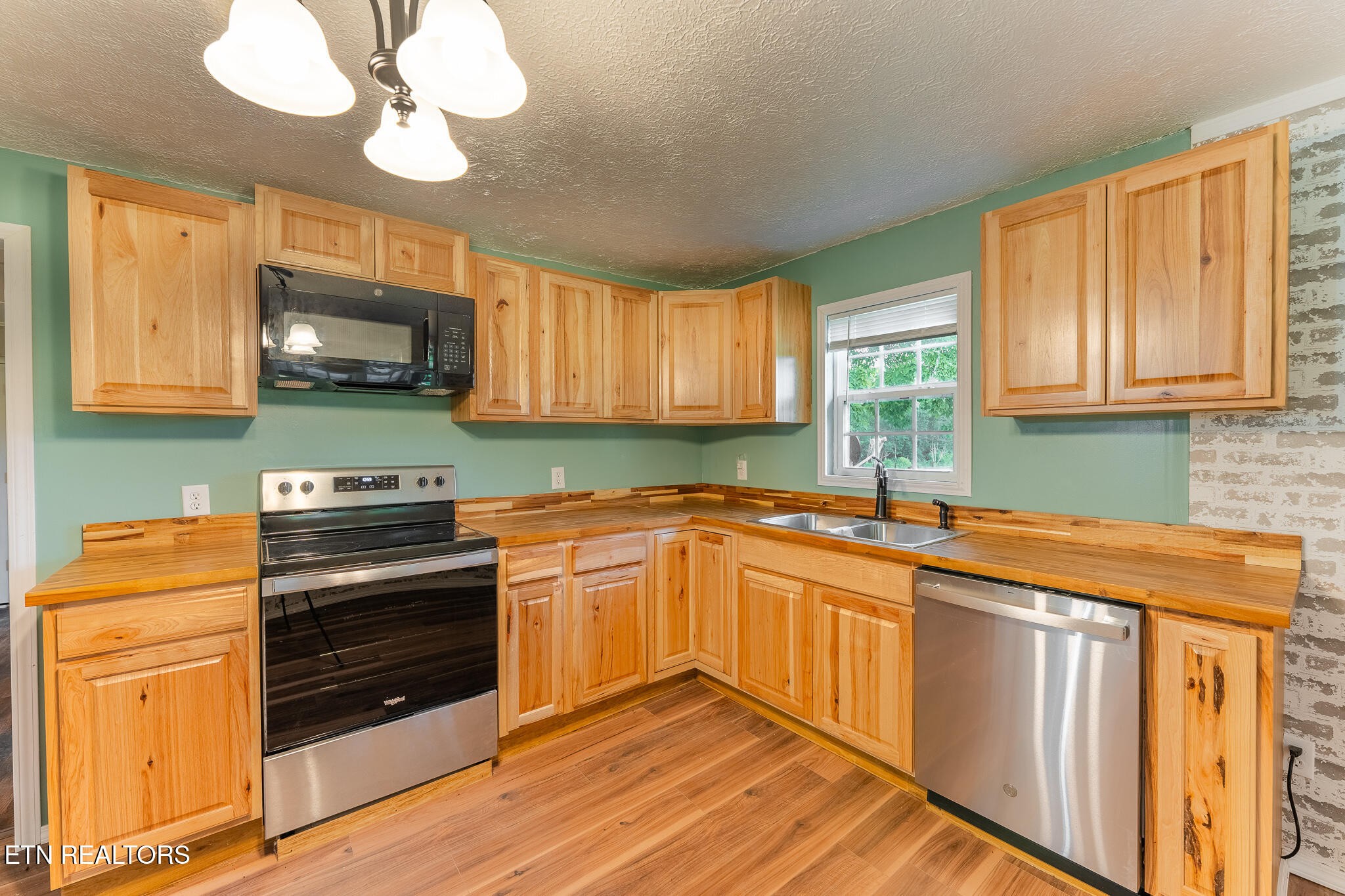 2530 Roslin Road Deer Lodge, TN 37726 - Photo 11 of 58 a kitchen with stainless steel appliances granite countertop wooden cabinets a stove a sink and dishwasher with wooden floor