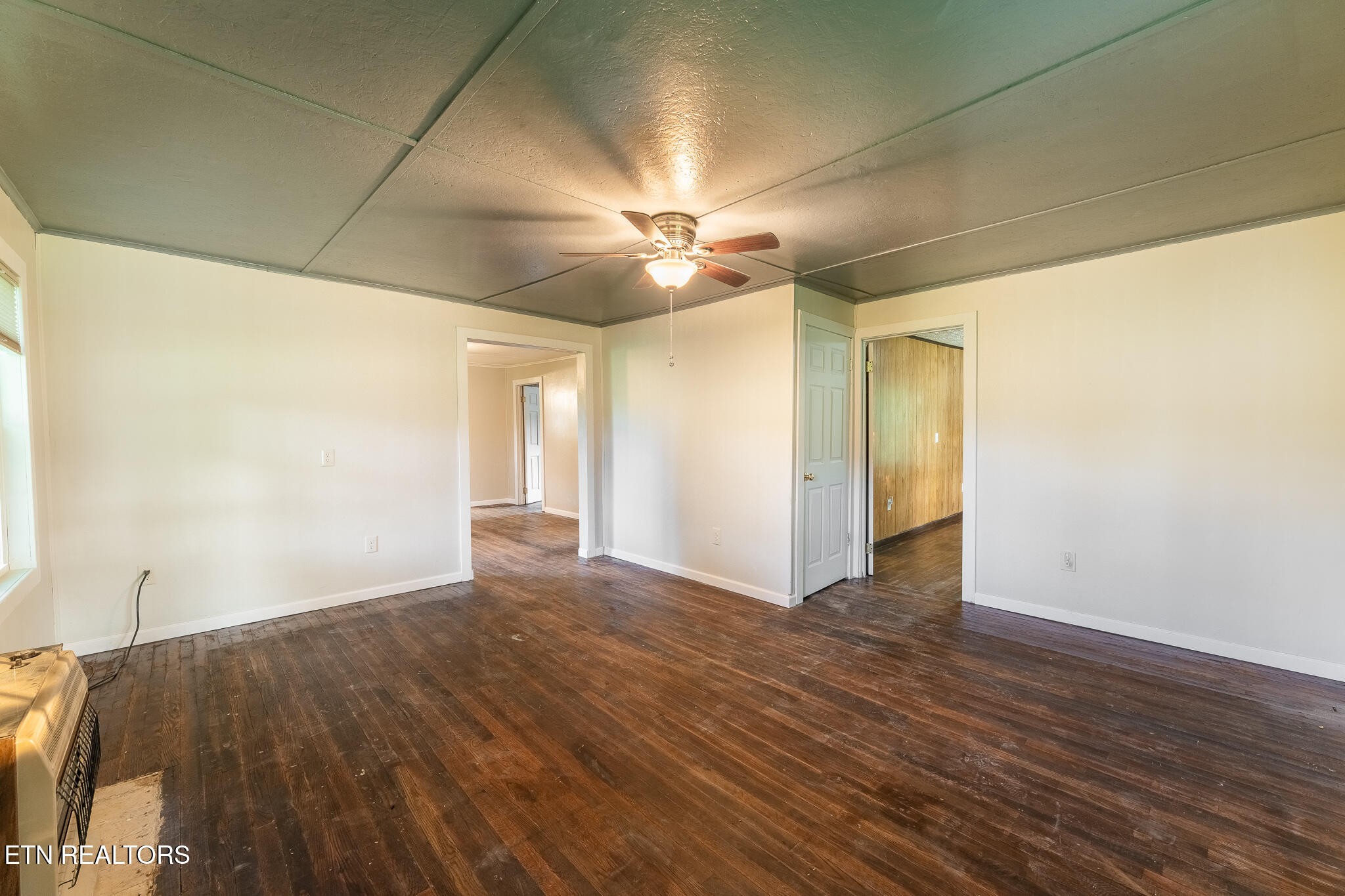 2530 Roslin Road Deer Lodge, TN 37726 - Photo 17 of 58 a view of an empty room with wooden floor and a ceiling fan