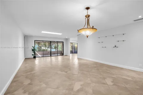 a view of an empty room with potted plants and large window