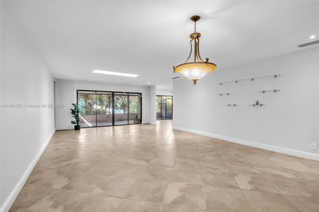 a view of an empty room with potted plants and large window