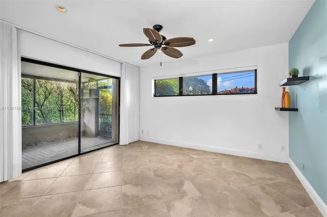 a view of an empty room with a chandelier fan