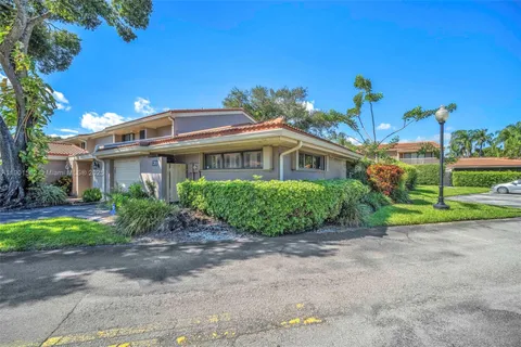 a front view of a house with a yard and potted plants