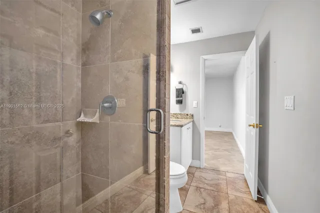 a view of an empty room with chandelier fan