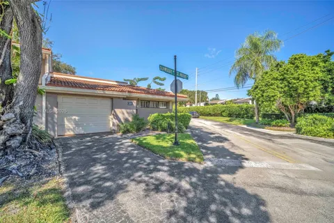 a view of a house with a yard and potted plants