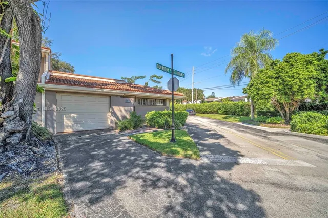 a view of a house with a yard and potted plants