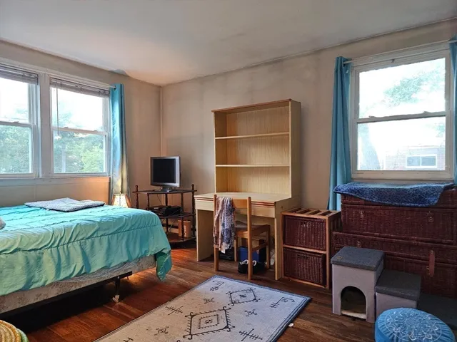 a bedroom with bed and two windows