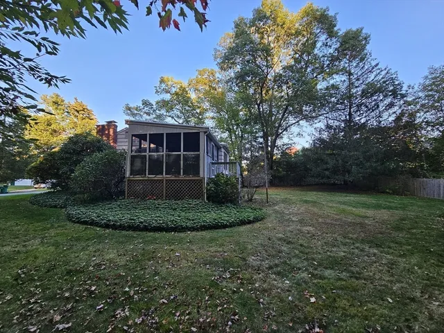 a view of a house with a yard and a tree
