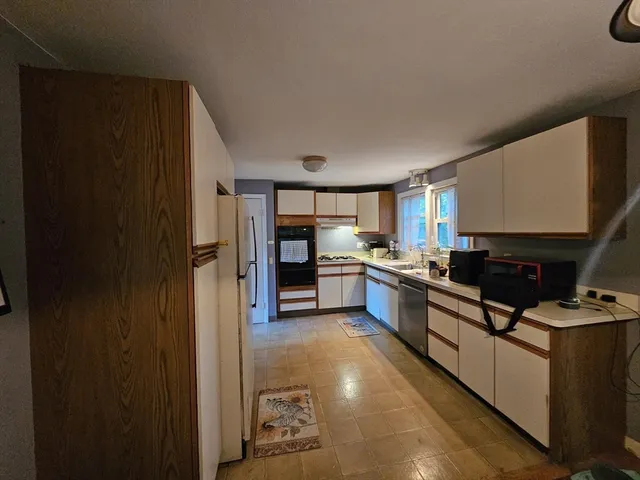 a kitchen with stainless steel appliances granite countertop a refrigerator and a stove
