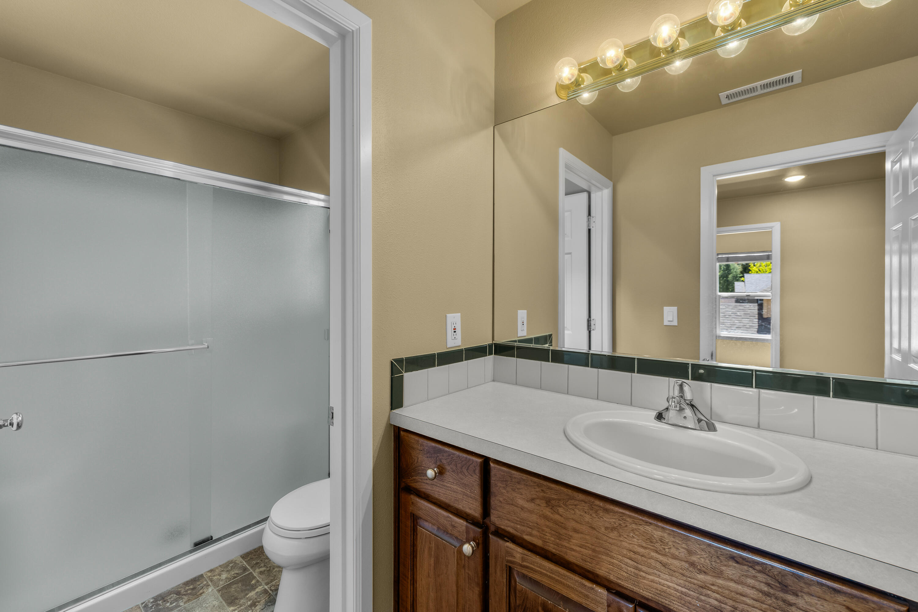 19307 Blue Lake Loop Bend, OR 97702 - Photo 41 of 58 a bathroom with a granite countertop sink a toilet and a mirror