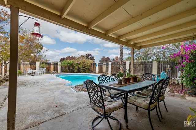 a view of a patio with a table and chairs and potted plants