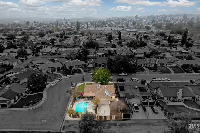 an aerial view of residential houses with outdoor space and trees
