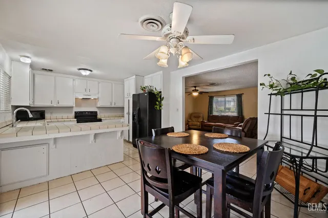 a view of a dining room with furniture and a chandelier fan