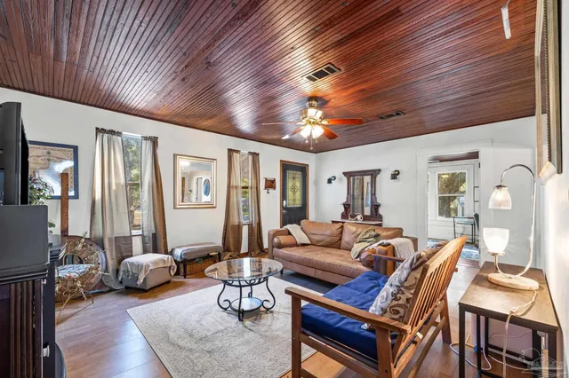 a living room with furniture a flat screen tv and kitchen view