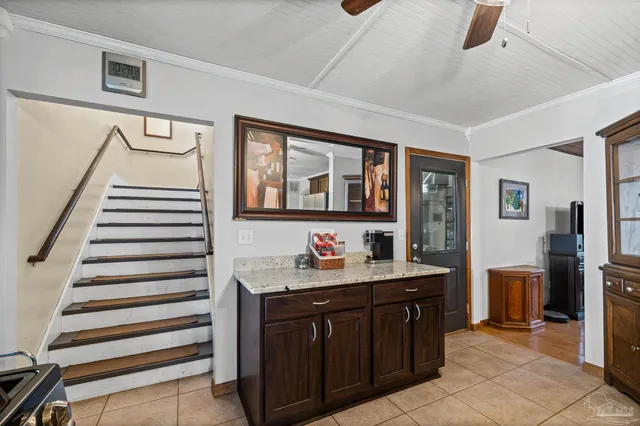 a kitchen with stainless steel appliances granite countertop a stove top oven a sink a dining table and chairs with wooden floor