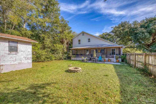 a view of a house with garden and a tree