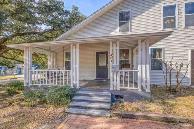 a view of a house with backyard and trees