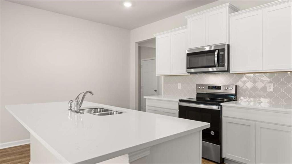 306 Friendship Oak Way Hampton, GA 30228 - Photo 11 of 41 a kitchen with a sink a stove and microwave