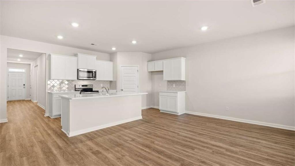 306 Friendship Oak Way Hampton, GA 30228 - Photo 10 of 41 a kitchen with granite countertop white cabinets and stainless steel appliances