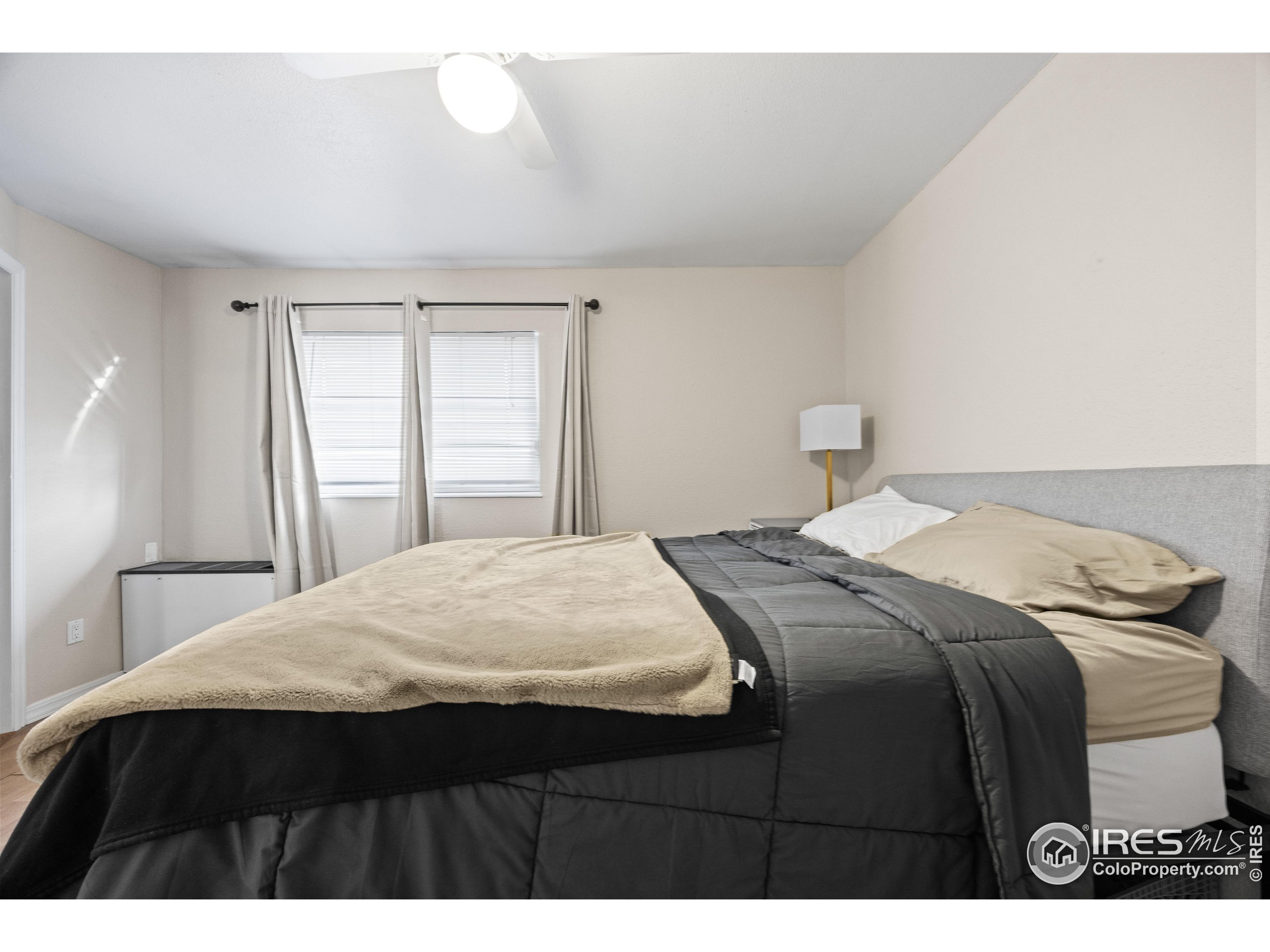 3009 Madison Avenue, Unit 315 Boulder, CO 80303 - Photo 14 of 17 a bedroom with a bed and wooden floor