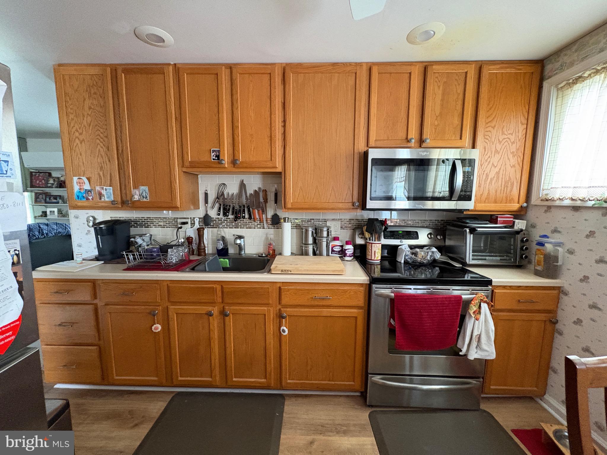 15 South Forklanding Road Maple Shade, NJ 08052 - Photo 4 of 30 a kitchen with stainless steel appliances wooden cabinets and a stove top oven