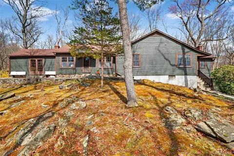 a front view of a house with a yard covered in snow