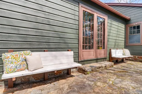 a view of a house with a wooden bench