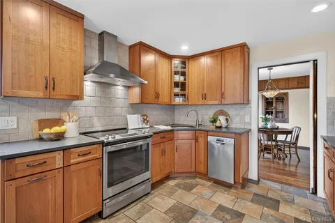 a kitchen with stainless steel appliances granite countertop a stove a sink and a refrigerator