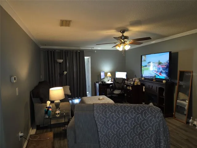 a living room with furniture a chandelier and a flat screen tv