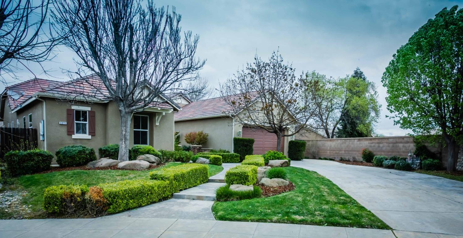 a front view of a house with a yard and a garden