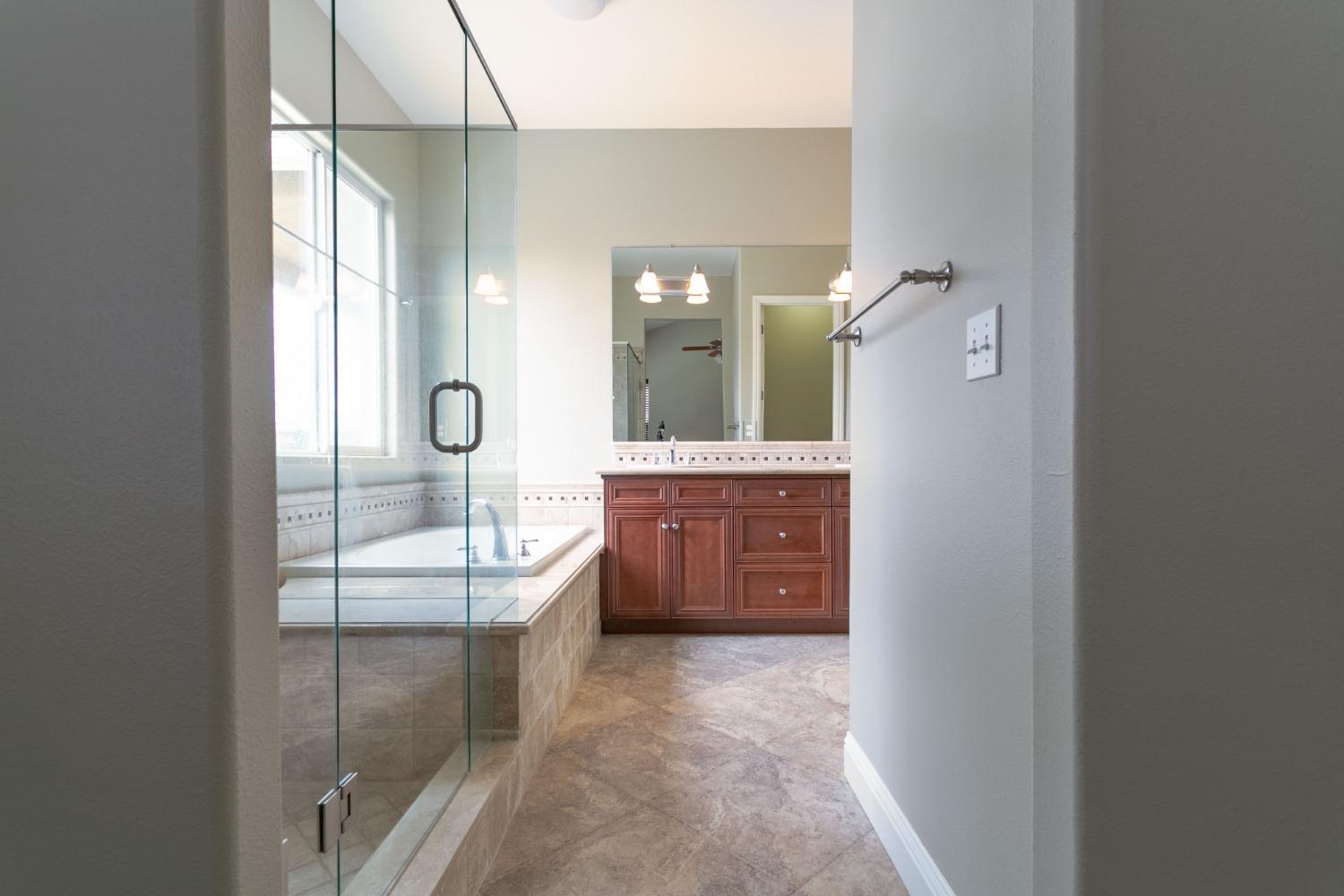 3271 Graybark Avenue Clovis, CA 93619 - Photo 11 of 26 a bathroom with a tub sink and mirror
