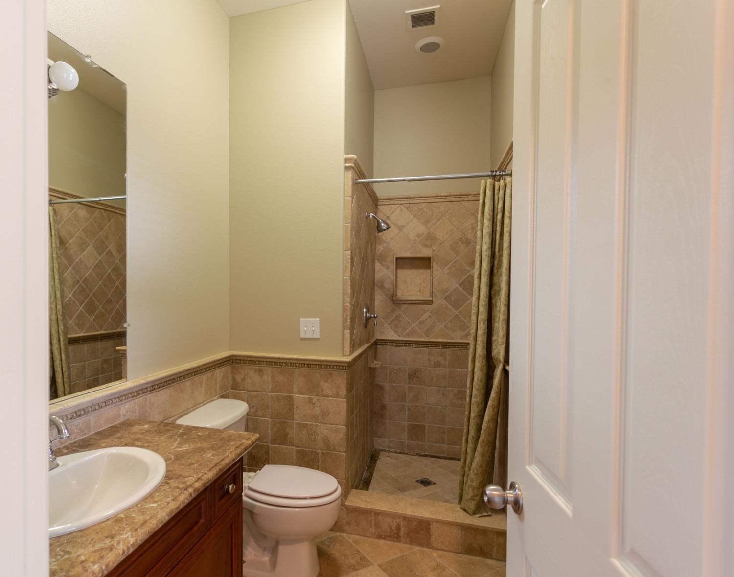 3271 Graybark Avenue Clovis, CA 93619 - Photo 14 of 26 a bathroom with a granite countertop sink toilet and shower