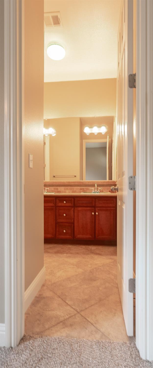 3271 Graybark Avenue Clovis, CA 93619 - Photo 16 of 26 a bathroom with a double vanity sink and a mirror