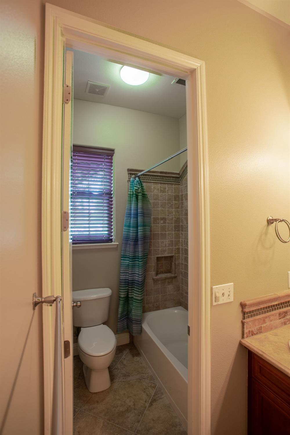 3271 Graybark Avenue Clovis, CA 93619 - Photo 18 of 26 a bathroom with a toilet and a bathtub