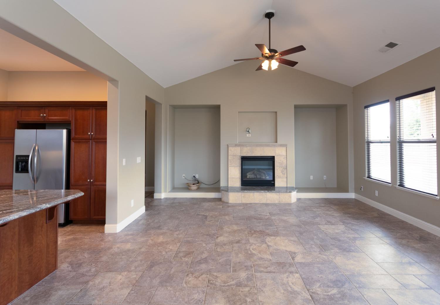 3271 Graybark Avenue Clovis, CA 93619 - Photo 6 of 26 a view of an empty room with a fireplace and a window