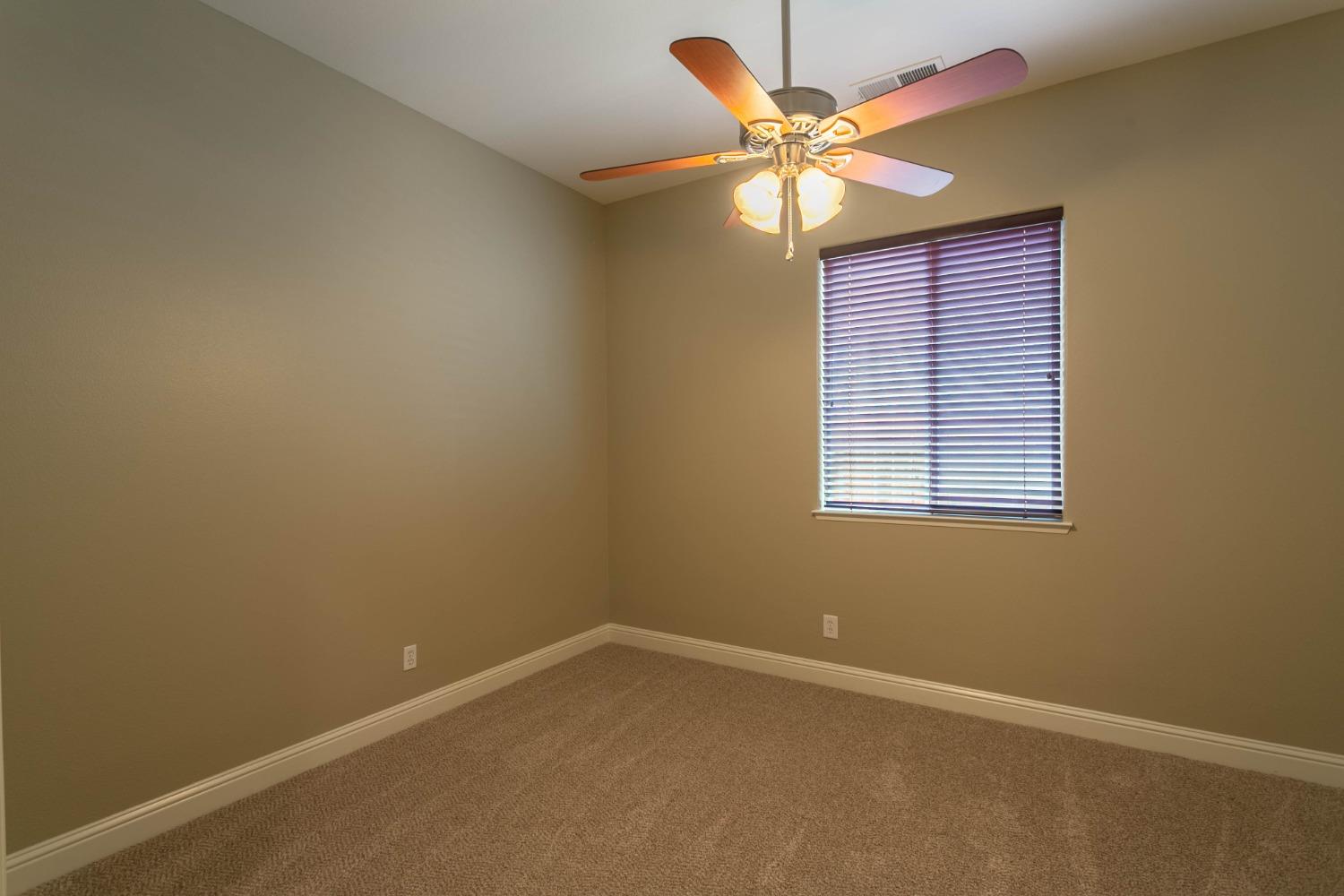 3271 Graybark Avenue Clovis, CA 93619 - Photo 10 of 26 an empty room with a window and a ceiling fan