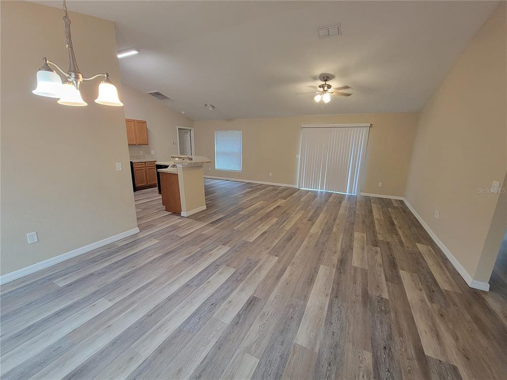 7009 Hemlock Road Ocala, FL 34472 - Photo 2 of 10 a view of empty room with wooden floor and ceiling fan