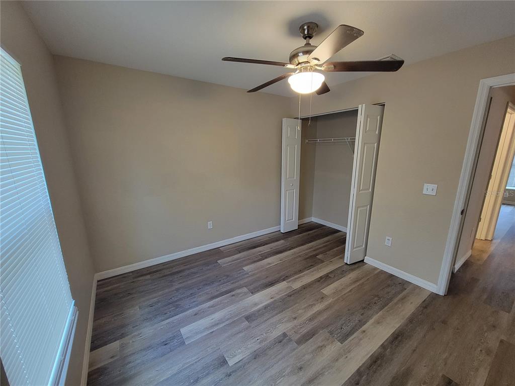 7009 Hemlock Road Ocala, FL 34472 - Photo 7 of 10 wooden floor in an empty room with a mirror