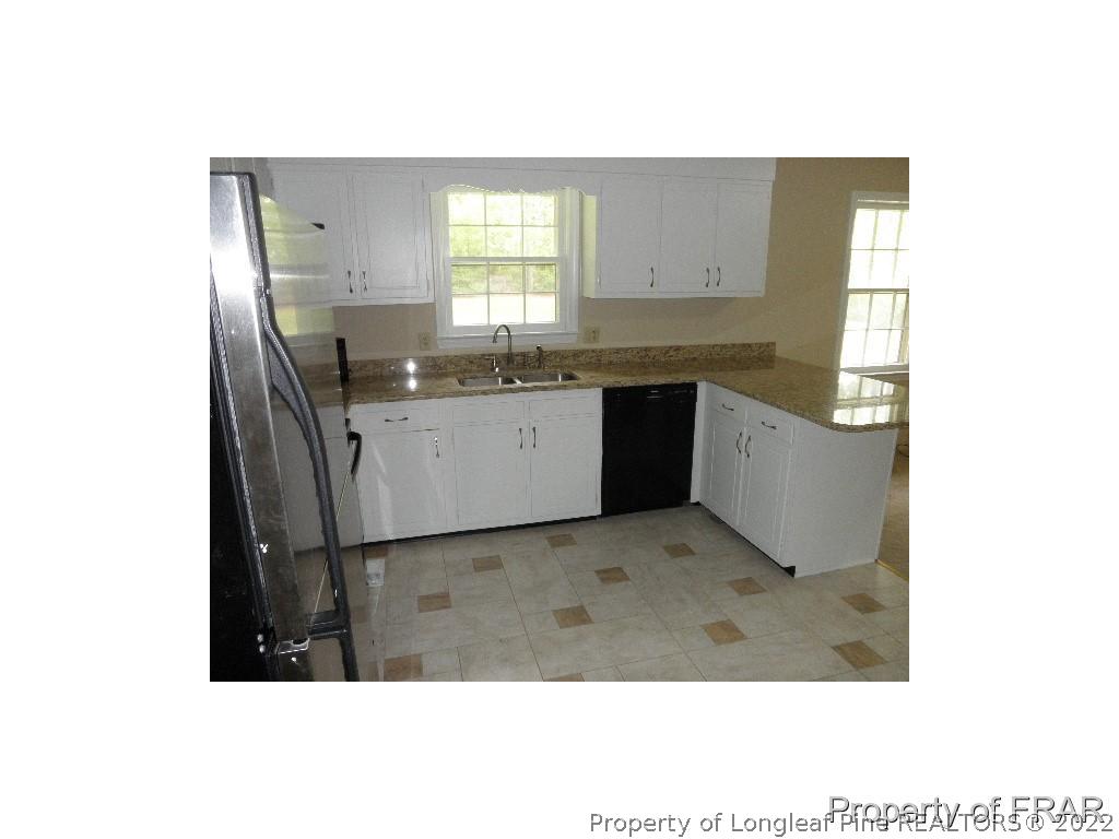 4753 Legion Road Hope Mills, NC 28348 - Photo 8 of 22 a kitchen with granite countertop a sink and cabinets