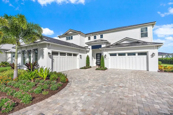 a kitchen with stainless steel appliances kitchen island granite countertop a refrigerator a stove and a sink with wooden floor