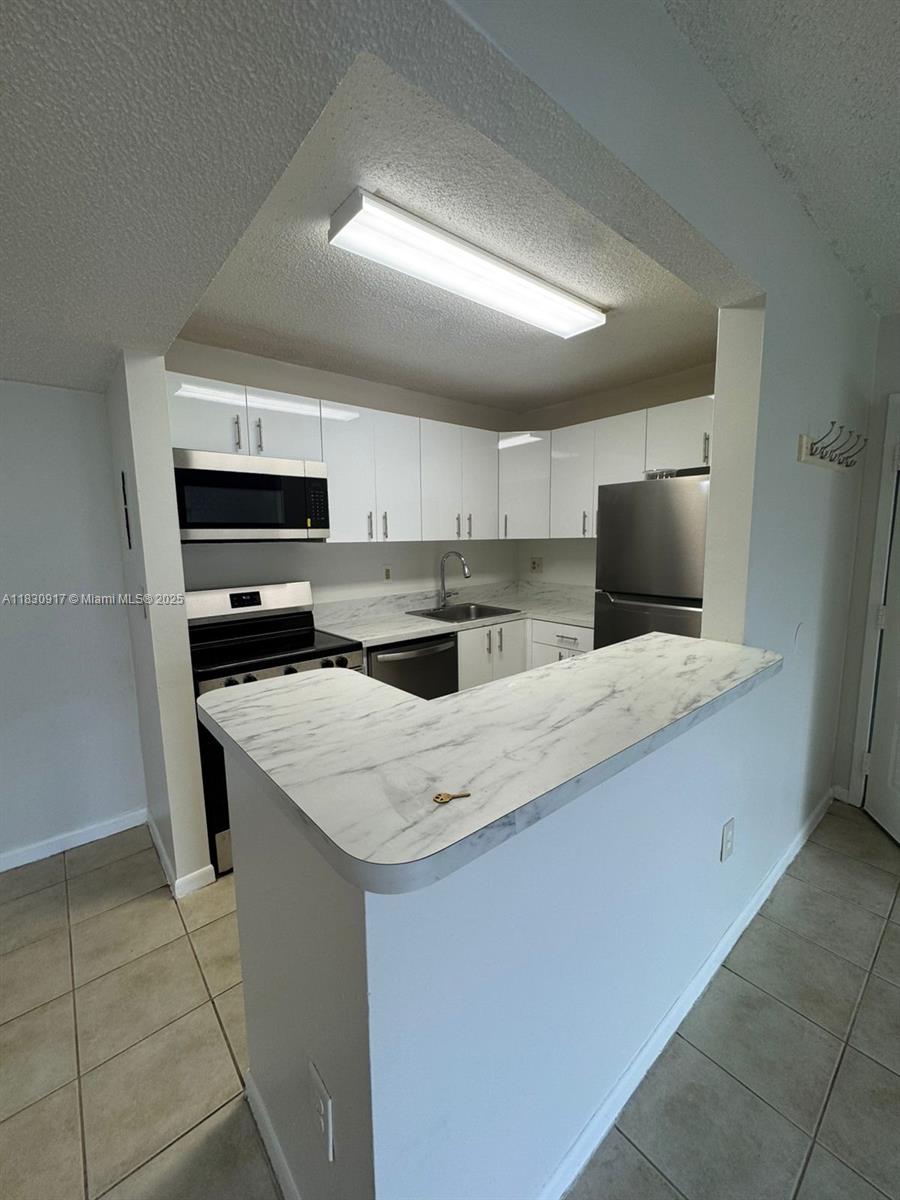 a kitchen with kitchen island a sink appliances and cabinets