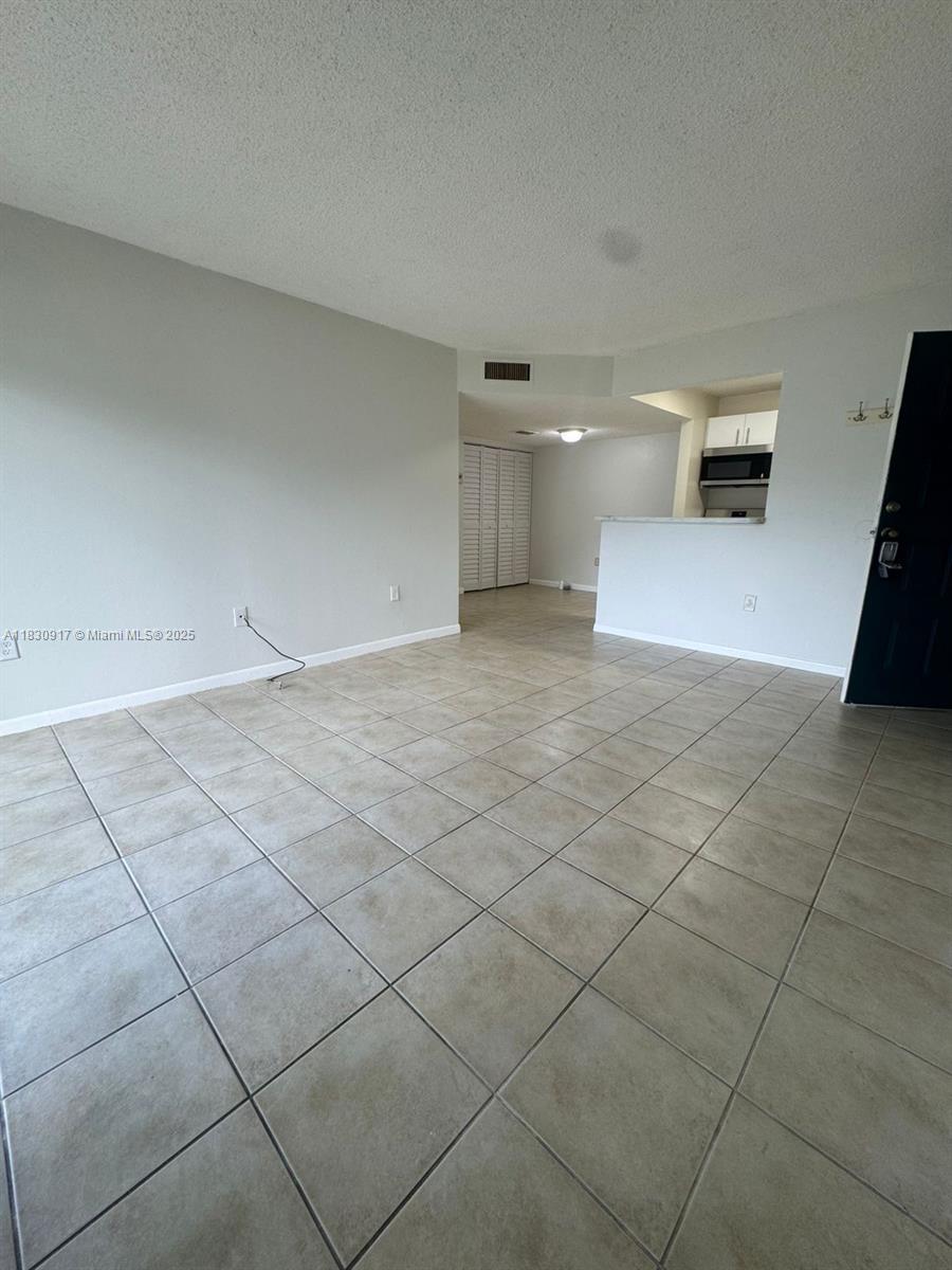 7180 Northwest 179th Street, Unit 109 Hialeah, FL 33015 - Photo 11 of 17 a view of an empty room and a window