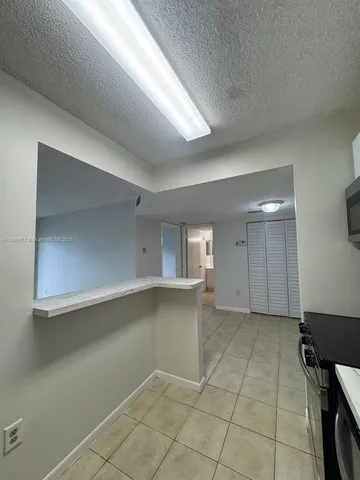 an empty room with a fireplace and windows