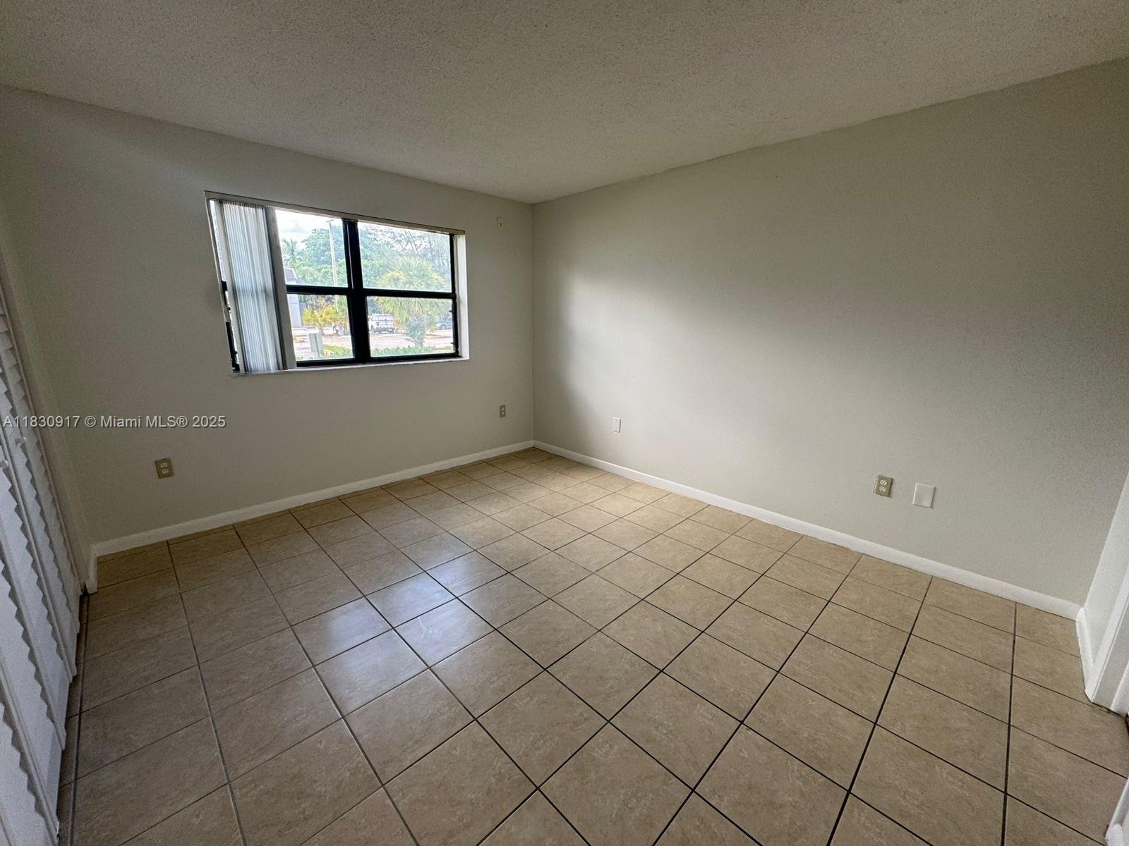 7180 Northwest 179th Street, Unit 109 Hialeah, FL 33015 - Photo 14 of 17 an empty room with windows