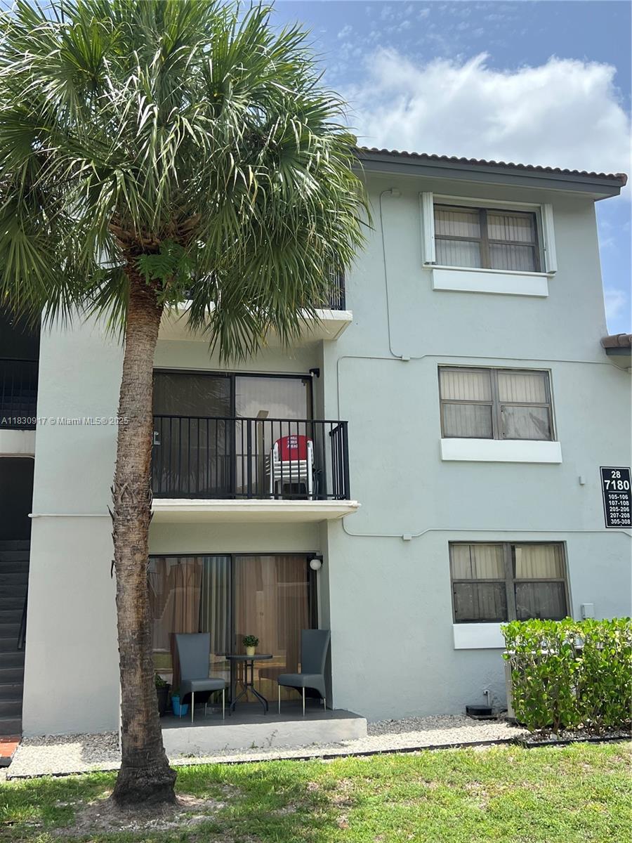 7180 Northwest 179th Street, Unit 109 Hialeah, FL 33015 - Photo 16 of 17 a small pool with a lawn chairs under an umbrella
