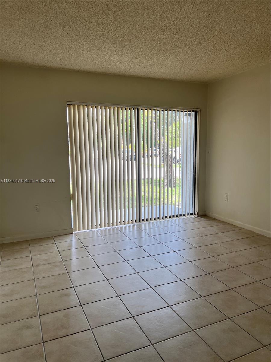 7180 Northwest 179th Street, Unit 109 Hialeah, FL 33015 - Photo 2 of 17 a view of an empty room with a window